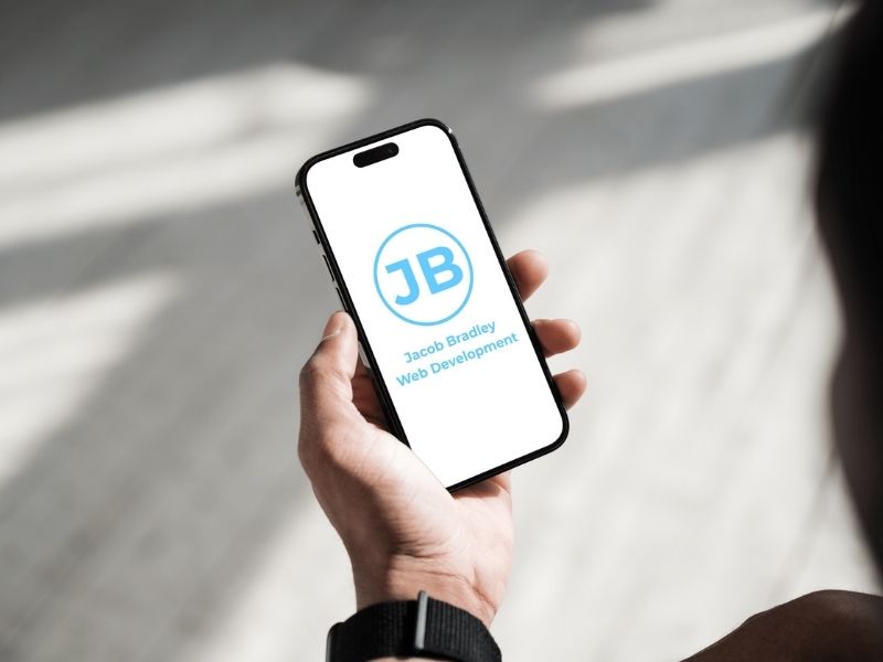 A phone displaying Jacob Bradley Web Development logo.